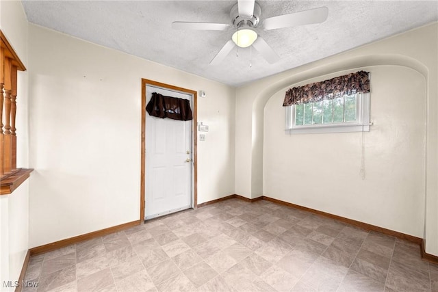 2021 17th St NE, Canton, OH 44705 - spare room with a textured ceiling, baseboards, arched walkways, and a ceiling fan