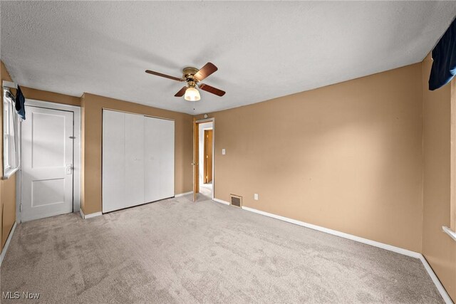 2021 17th St NE, Canton, OH 44705 - unfurnished bedroom with carpet floors, baseboards, ceiling fan, a closet, and a textured ceiling