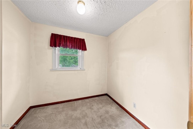 2021 17th St NE, Canton, OH 44705 - spare room with light carpet, a textured ceiling, and baseboards