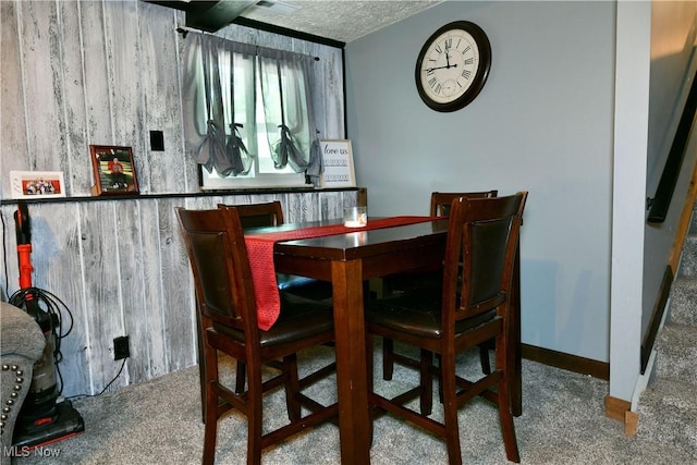 dining area featuring carpet floors and a textured ceiling