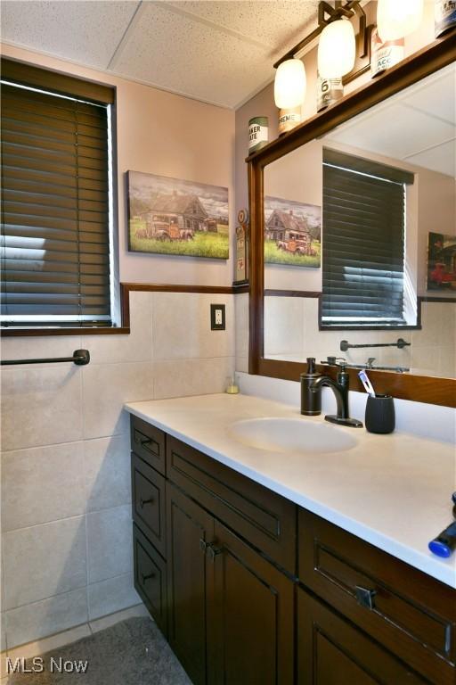 bathroom featuring vanity and tile walls