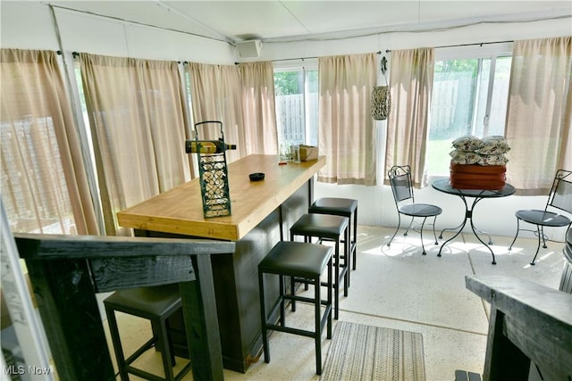 dining area with speckled floor and a wall mounted AC