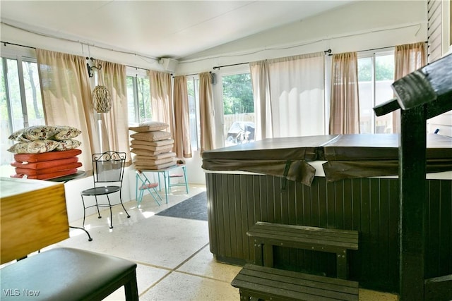 sunroom / solarium with a jacuzzi, speckle patterned floor, and lofted ceiling