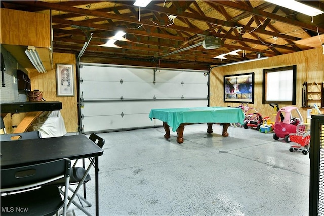 garage with a garage door opener and wooden walls
