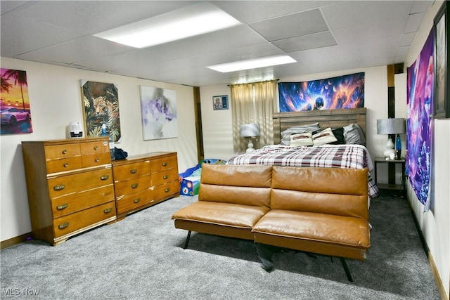 carpeted bedroom featuring a drop ceiling and baseboards