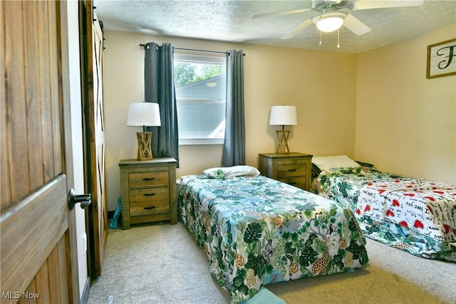 bedroom featuring light carpet, a textured ceiling, and ceiling fan