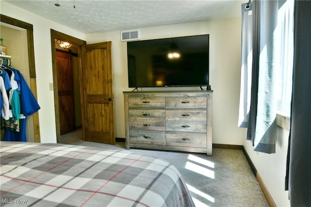 bedroom featuring carpet floors, baseboards, and a textured ceiling