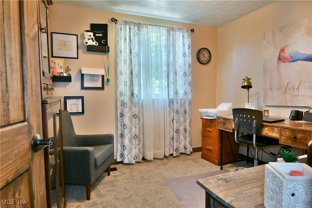 carpeted home office featuring a textured ceiling