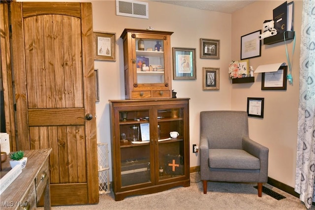 sitting room featuring carpet flooring and baseboards
