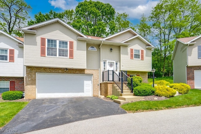 75 River Ridge Lane, Munroe Falls, OH 44262 - bi-level home featuring a garage, asphalt driveway, and brick siding