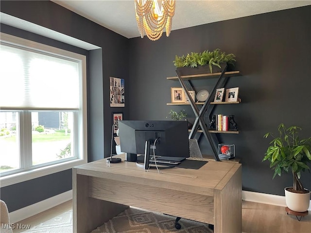 office with baseboards, a chandelier, and wood finished floors