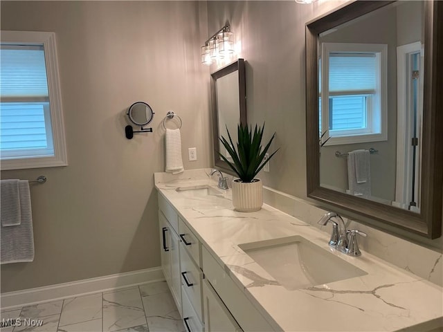full bathroom with marble look tiles, baseboards, and double vanity