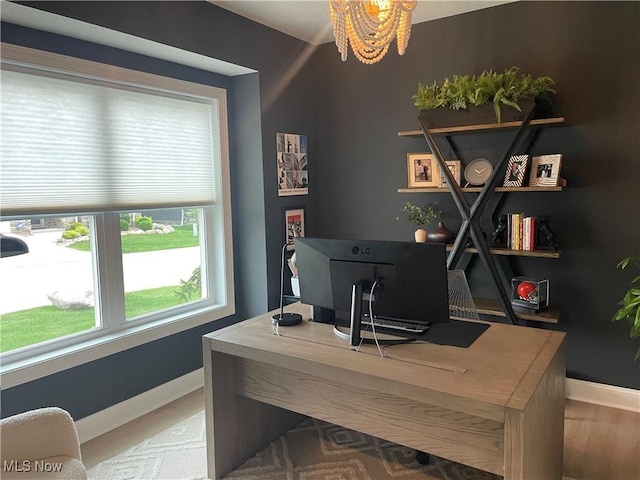 office with baseboards, a chandelier, and wood finished floors