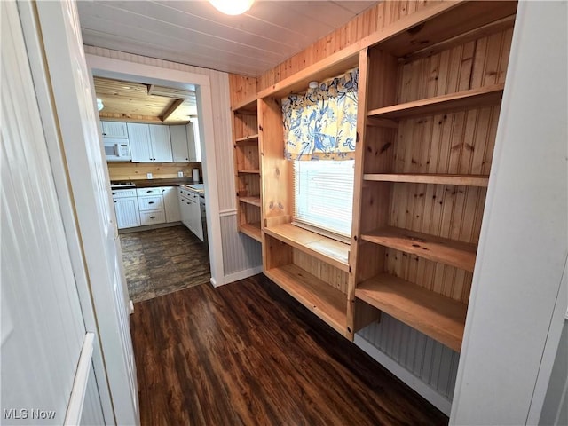mudroom with dark wood-type flooring, wooden walls, and wood ceiling