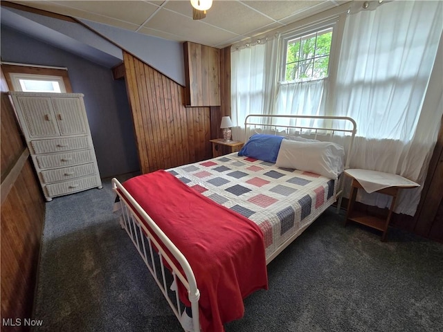 bedroom featuring wood walls and carpet
