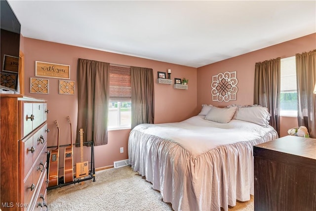 bedroom with light colored carpet and baseboards
