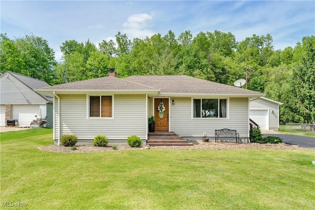 ranch-style home featuring a front lawn, an outbuilding, a detached garage, and a chimney