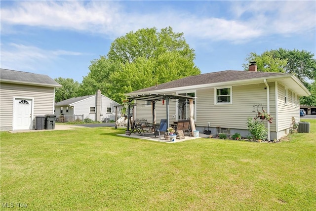 rear view of property with central AC unit, a patio, a chimney, and a yard