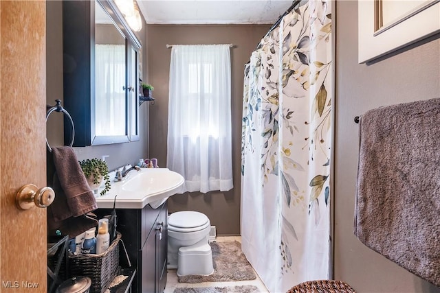 full bath with toilet, vanity, a shower with shower curtain, and baseboards