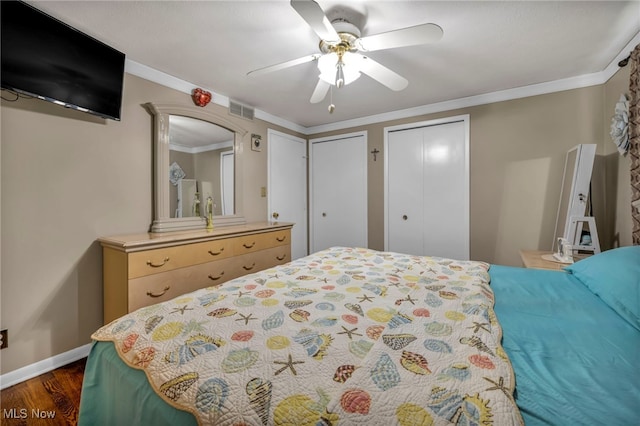 3226 Woodlawn Dr, Parma, OH 44134 - bedroom featuring two closets, dark wood finished floors, baseboards, ceiling fan, and arched walkways