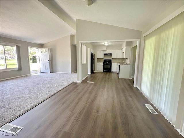 1400 Yale Dr, Brunswick, OH 44212 - unfurnished living room with vaulted ceiling, baseboards, and dark wood-type flooring