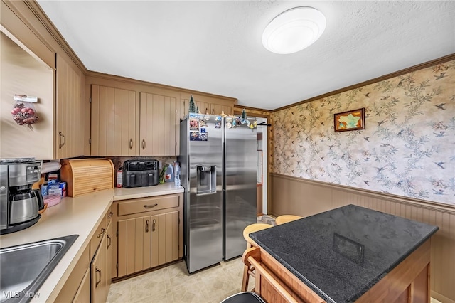 6395 Easton St NE, Louisville, OH 44641 - kitchen featuring stainless steel fridge, wainscoting, a sink, light countertops, and crown molding