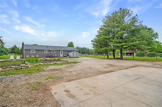 6395 Easton St NE, Louisville, OH 44641 - view of front facade with driveway, a shed, an outdoor structure, and fence