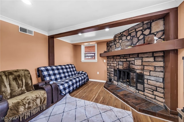 6395 Easton St NE, Louisville, OH 44641 - living area featuring wood finished floors, baseboards, ornamental molding, recessed lighting, and a stone fireplace