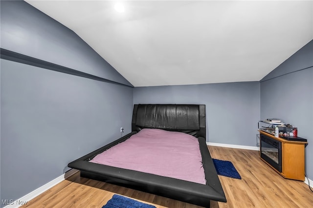 6395 Easton St NE, Louisville, OH 44641 - bedroom featuring lofted ceiling, light wood finished floors, and baseboards