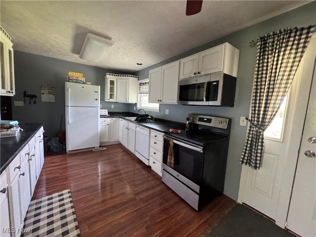 61272 Salem Rd, Salesville, OH 43778 - kitchen with appliances with stainless steel finishes, dark countertops, a sink, dark wood-style flooring, and a textured ceiling