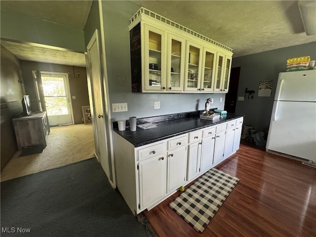 61272 Salem Rd, Salesville, OH 43778 - kitchen with freestanding refrigerator, dark wood finished floors, dark countertops, a textured ceiling, and glass insert cabinets