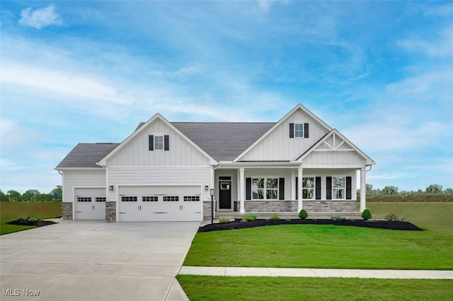 3186 Stoneleigh Rd NE, Canton, OH 44721 - view of front of property featuring board and batten siding, driveway, stone siding, and a front lawn