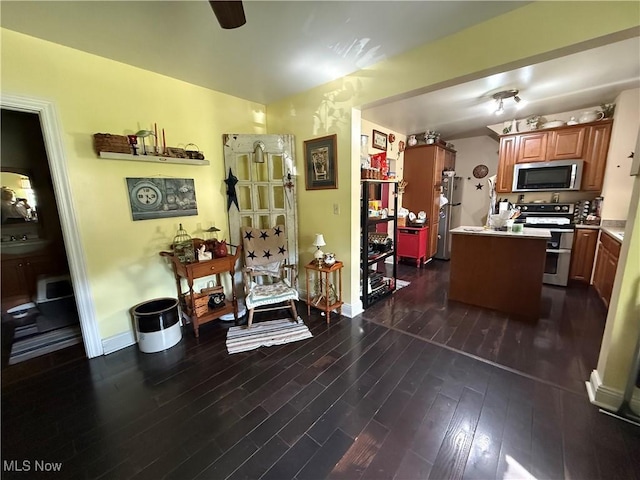 1710 Clairmont Ave, Cambridge, OH 43725 - kitchen with stainless steel appliances, dark wood-type flooring, a kitchen island, light countertops, and brown cabinets