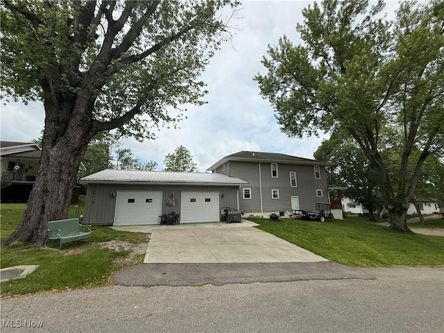 1710 Clairmont Ave, Cambridge, OH 43725 - tri-level home featuring concrete driveway, a front lawn, an outdoor structure, a garage, and metal roof