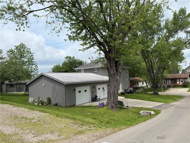 1710 Clairmont Ave, Cambridge, OH 43725 - view of front facade with a front lawn, a trampoline, metal roof, driveway, and an attached garage