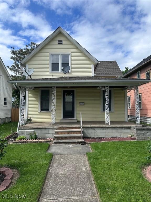 1334 W 6th St, Lorain, OH 44052 - view of front of property with covered porch, a front yard, and a shingled roof