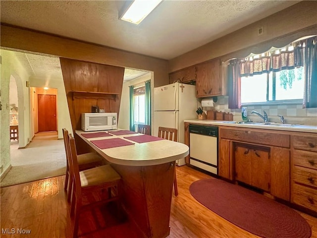 1010 Park Cir, Girard, OH 44420 - kitchen with white appliances, a sink, light countertops, light wood finished floors, and brown cabinets