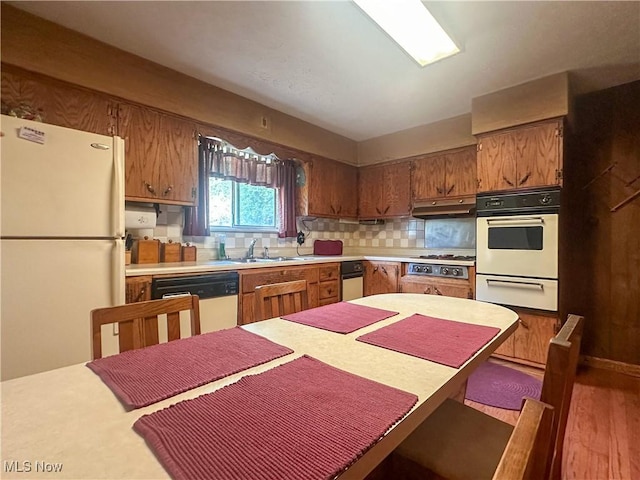 1010 Park Cir, Girard, OH 44420 - kitchen featuring white appliances, a warming drawer, light countertops, a sink, and under cabinet range hood