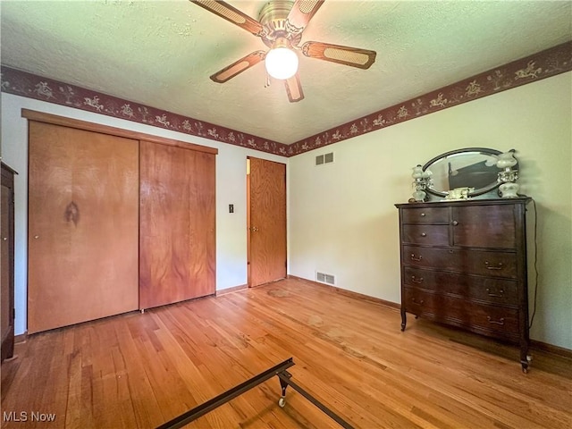 1010 Park Cir, Girard, OH 44420 - unfurnished bedroom with wood-type flooring, baseboards, a textured ceiling, and ceiling fan