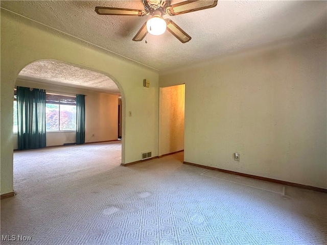 1010 Park Cir, Girard, OH 44420 - carpeted spare room featuring arched walkways, a textured ceiling, a ceiling fan, and baseboards