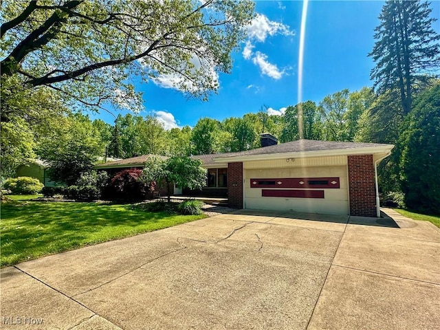 1010 Park Cir, Girard, OH 44420 - single story home with brick siding, a garage, driveway, a front yard, and a chimney