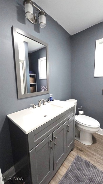 1300 Ethel Ave, Lakewood, OH 44107 - bathroom with wood finished floors, toilet, vanity, and baseboards