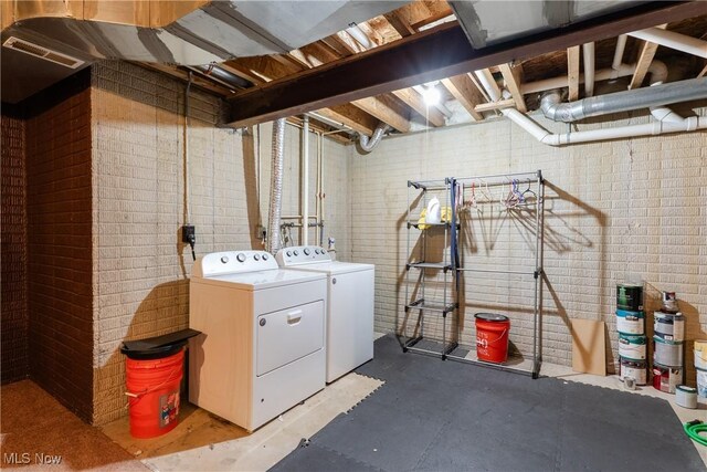 3602 Marvin Ave, Cleveland, OH 44109 - laundry area with independent washer and dryer and brick wall