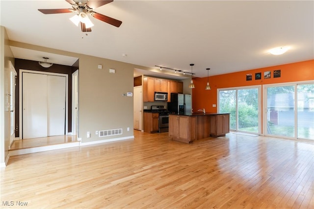 3602 Marvin Ave, Cleveland, OH 44109 - kitchen with stainless steel appliances, open floor plan, rail lighting, light wood-style floors, and dark countertops
