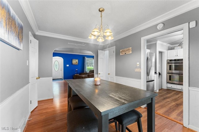 79 Leighton Ave, Youngstown, OH 44512 - dining room with arched walkways, a chandelier, wood finished floors, and ornamental molding