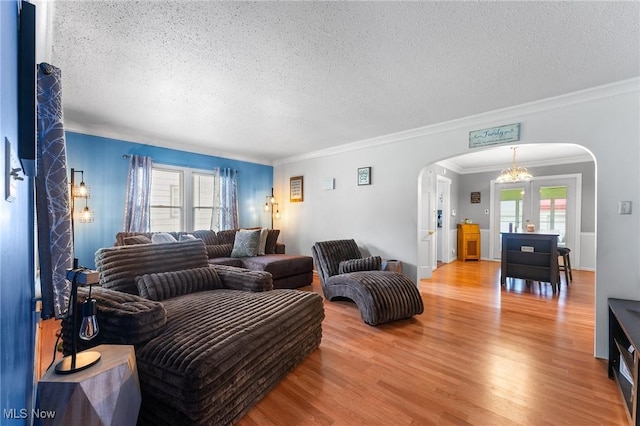 79 Leighton Ave, Youngstown, OH 44512 - living area with arched walkways, a textured ceiling, light wood-style flooring, crown molding, and a chandelier