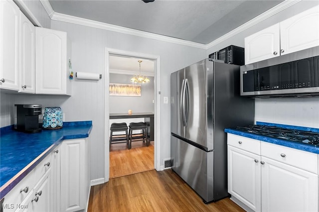 79 Leighton Ave, Youngstown, OH 44512 - kitchen with stainless steel appliances, dark wood finished floors, ornamental molding, dark countertops, and white cabinetry