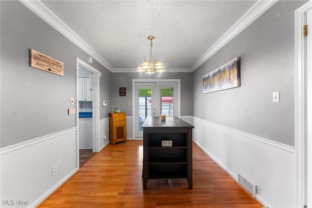79 Leighton Ave, Youngstown, OH 44512 - dining space with a chandelier, crown molding, light wood-type flooring, a textured ceiling, and french doors