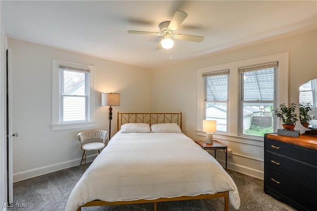 bedroom with dark colored carpet, baseboards, and ceiling fan