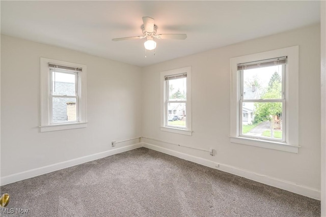 spare room featuring healthy amount of natural light, carpet, and baseboards